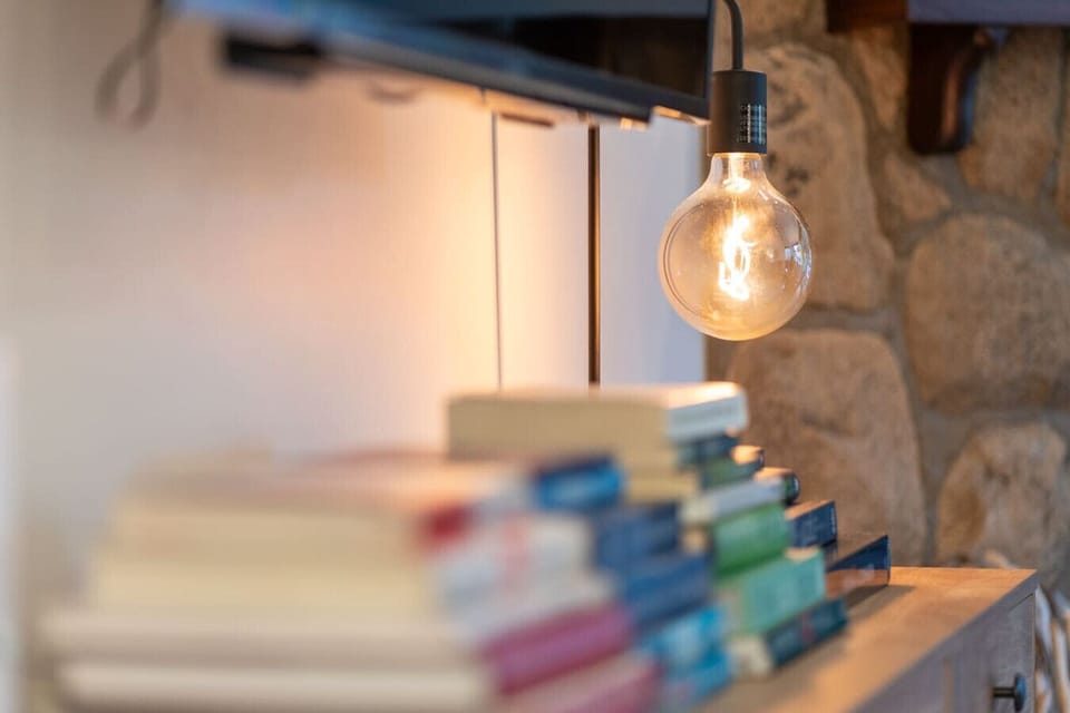 A warm reading nook with soft lighting and a stack of inviting books.