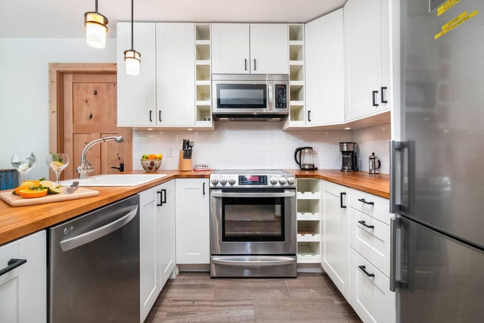 Pristine kitchen with ample cupboards, counter space, and modern appliances