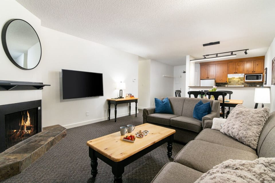 Cozy living room with pull-out sofa, fireplace, and private balcony seating