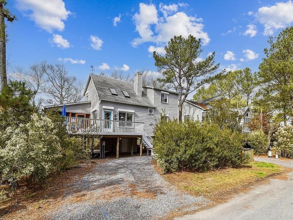 The exterior of the vacation home showcases a charming facade with ample parking space, inviting you to experience the comfort and convenience it has to offer.