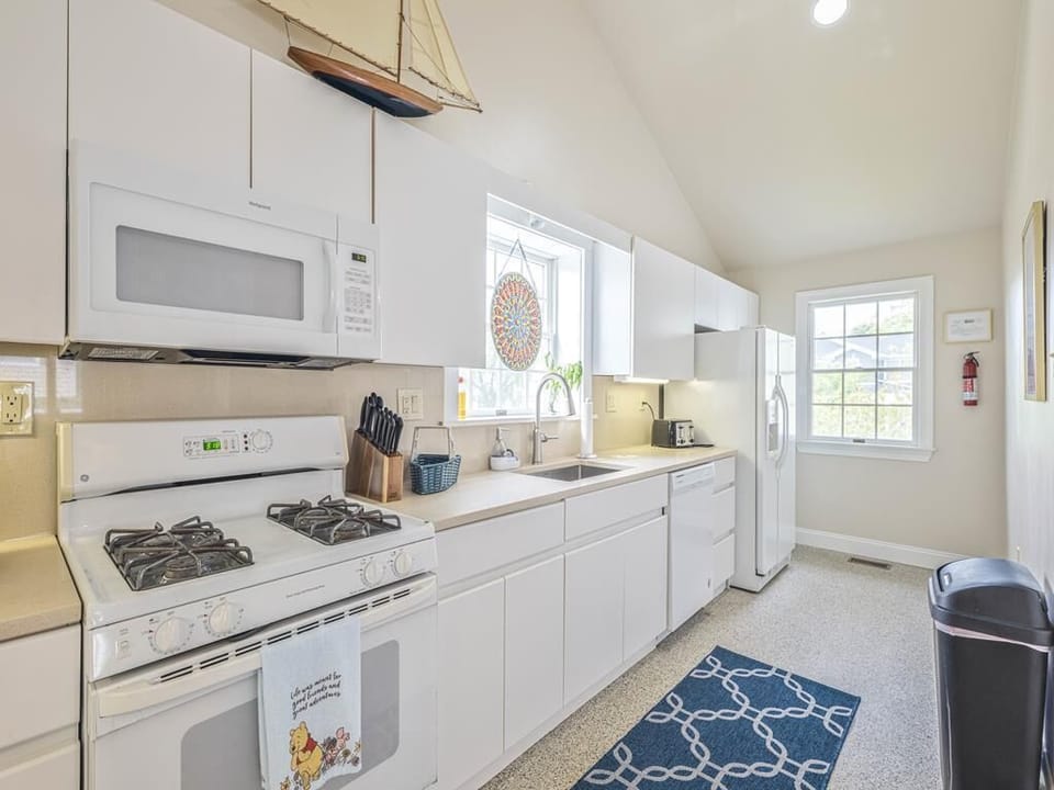 Bright and airy kitchen featuring a gas stove, microwave, and plenty of storage for extended stays.