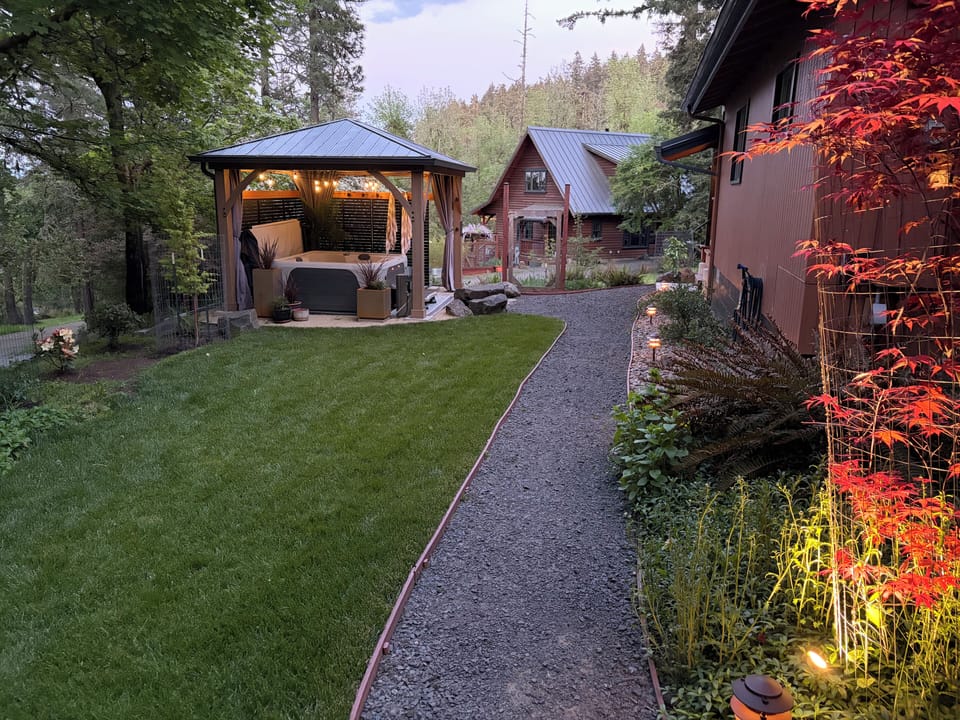 Side yard with gazebo and hot tub with Owner's cabin in the background.