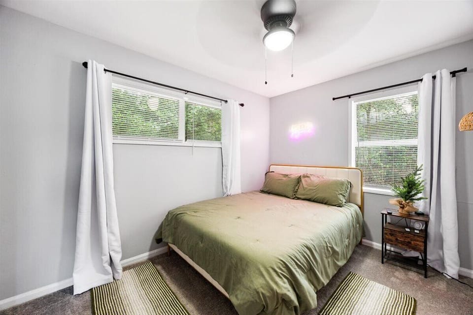 One of three bedrooms. Each bedroom features a Roku TV, a Queen size bed, a ceiling fan, and is fully carpeted.