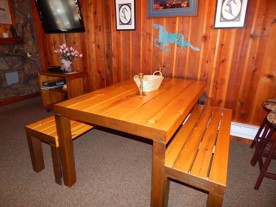 Gather around your rustic dining table where warm wood meets cozy cabin charm, perfect for sharing meals and making memories together.