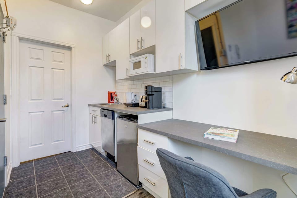 Fully equipped kitchenette with a microwave, coffee maker, and a mini-fridge.