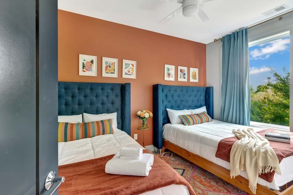 Two queen beds and a splash of color make this bedroom a comfortable retreat for two guests