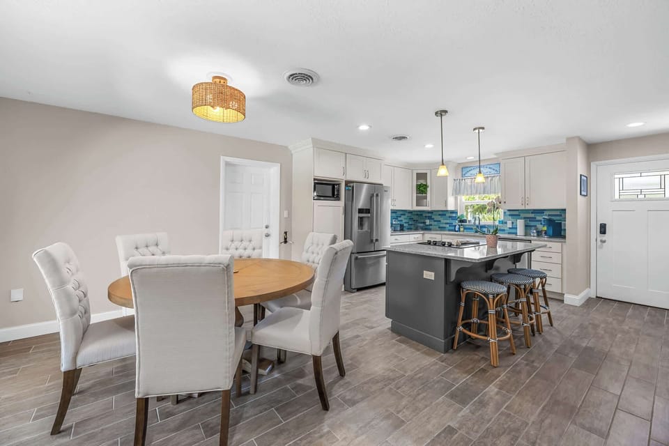 Modern kitchen with a blue tile backsplash and a breakfast bar with seating.