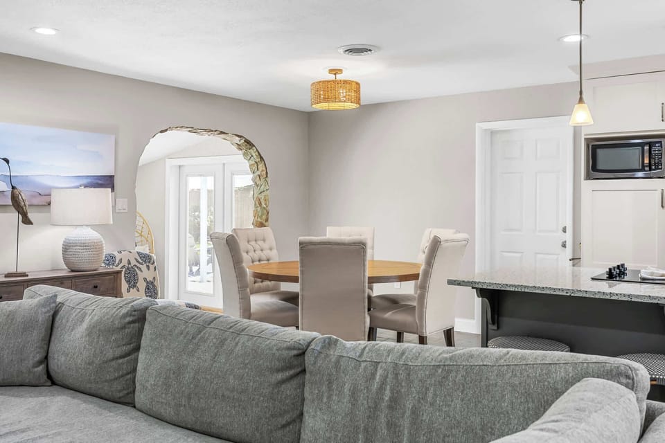Open dining area with cushioned chairs and natural light through glass doors