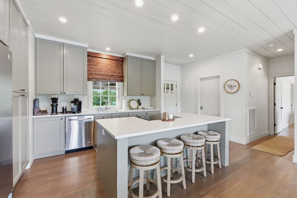 Large kitchen with dining table across from bar stool seats