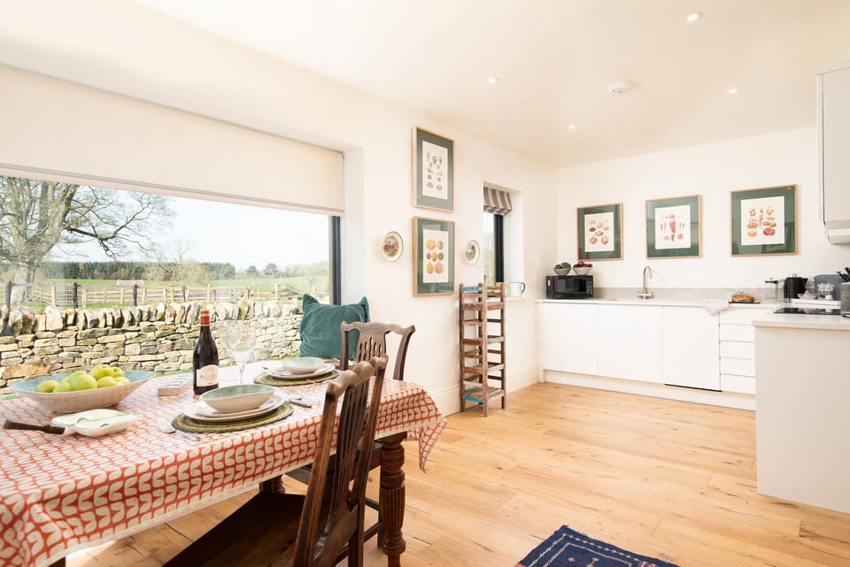 Lakeside Cottage - Edward - the open-plan kitchen and dining space benefits from a large corner window allowing light to beam in