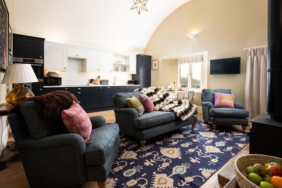 Lakeside Cottage - Alice - open-plan living space with a single-wall kitchen, dining area and comfortable seating around the log burner