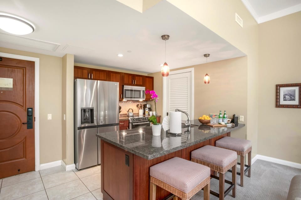 Stylish gourmet kitchen with granite countertops, stainless steel appliances, and bar seating HKH-114
