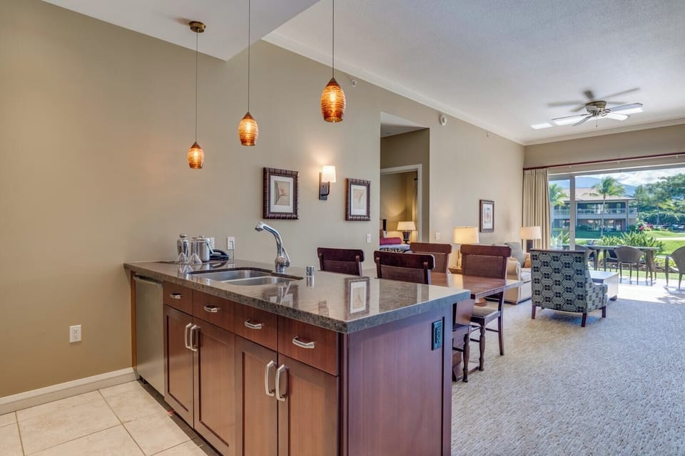 Modern kitchen island opens to bright living and lanai views. HKK-108