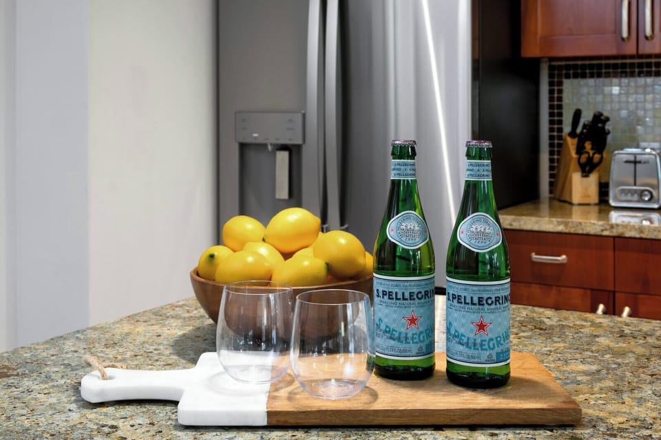 Refreshing San Pellegrino with lemons on granite kitchen island setup. HKK-220
