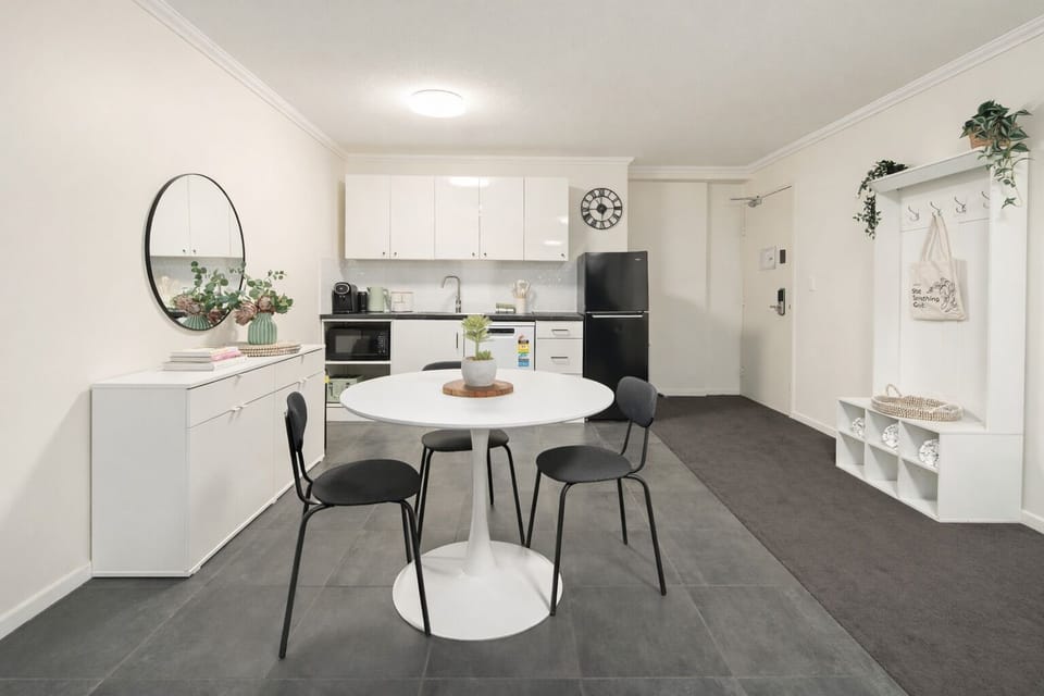The round dining table offers a cosy spot for relaxed meals, while the nearby entry nook with hooks and cubbies keeps beach towels, bags and everyday items neatly organised.