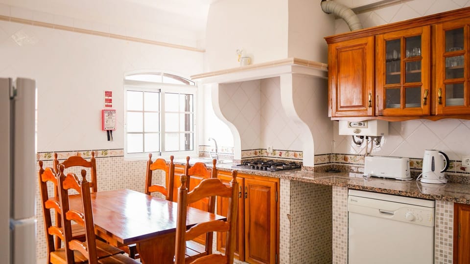 Enjoy home-cooked meals in this charming, well-equipped kitchen featuring a traditional design with modern touches. #HomeCookedMeals #FullyEquippedKitchen #TraditionalDesign #ModernTouches
