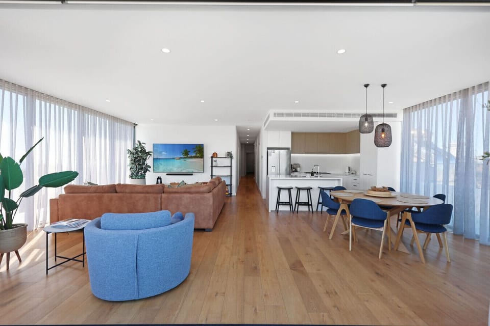 Bright and airy living space with full kitchen, dining area, and cozy seating