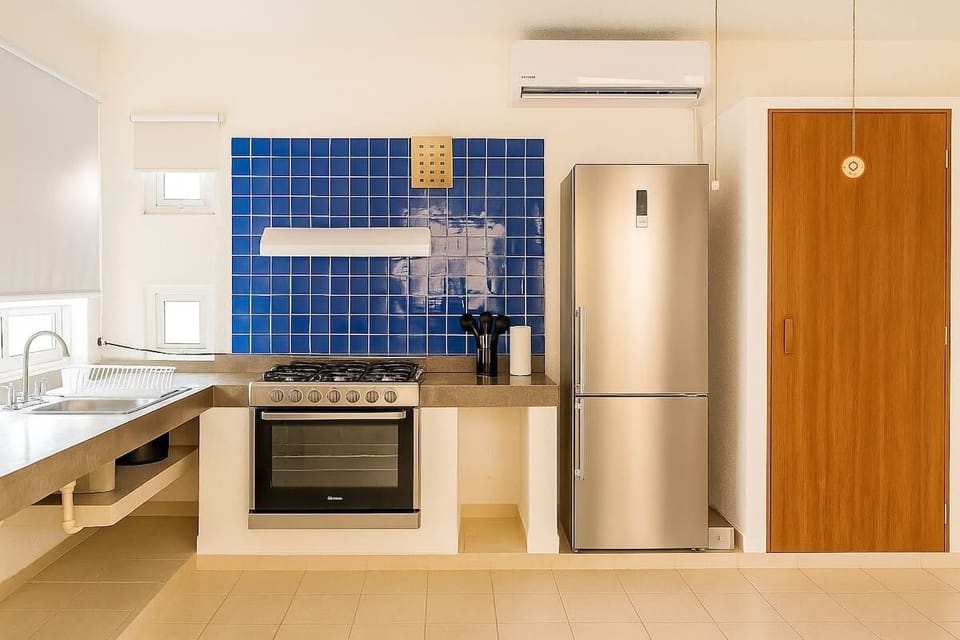 Kitchen with oven, stove and refrigerator.