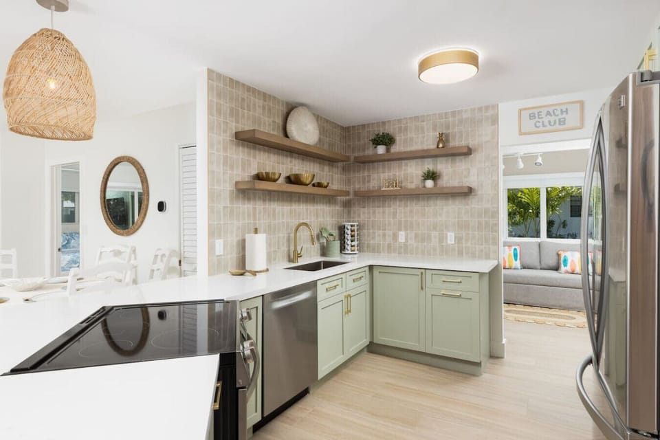 Bright and inviting kitchen space featuring natural wood shelves, modern appliances, and all the cookware and essentials you’ll need for meals at home with the family.