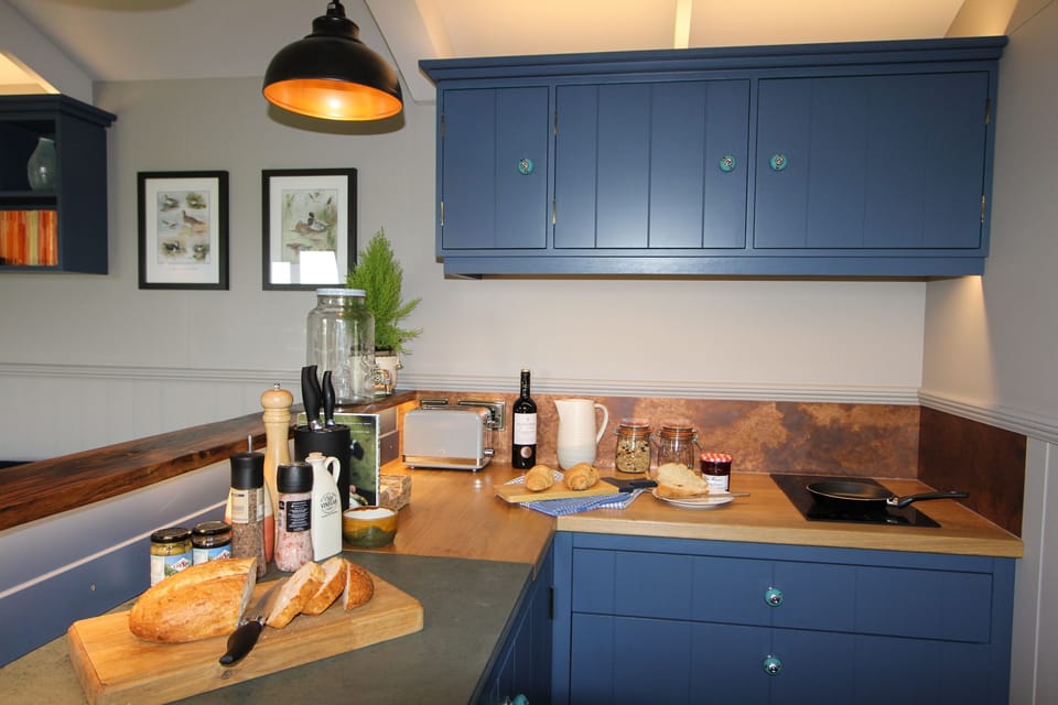 Shepherd's Lodge, Marsham: Kitchen area with a two-ring induction hob, a combi-microwave grill, integrated fridge and plenty of storage