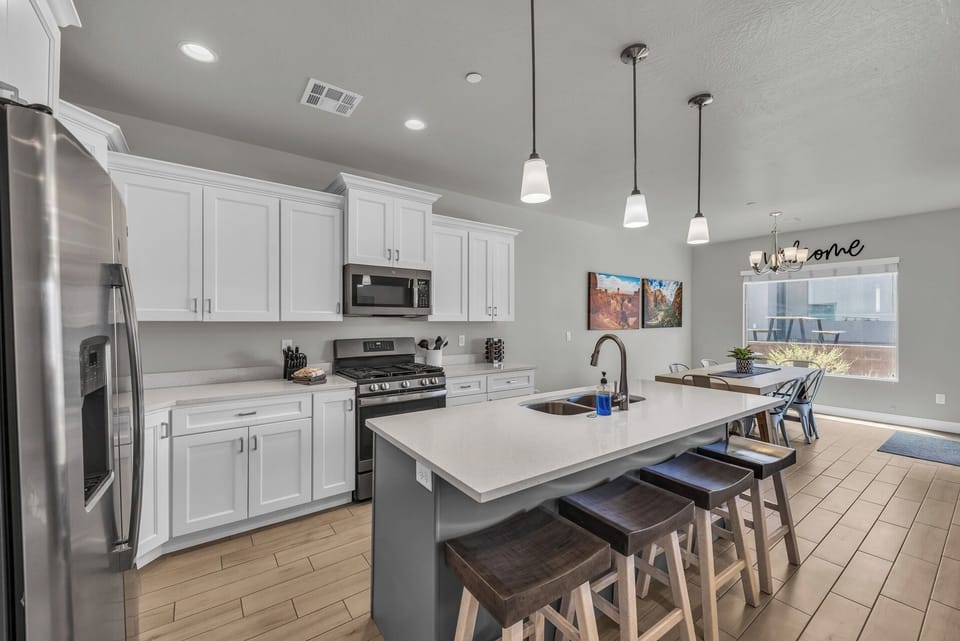 🍽️✨ Bright, modern kitchen with stainless appliances, gas range, and a large island for meals, prep, and gathering—perfectly open to the dining area for easy entertaining.
