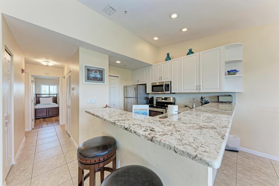 Your fully-equipped kitchen features granite countertops, stainless steel appliances, and a convenient breakfast bar where you can enjoy morning coffee.