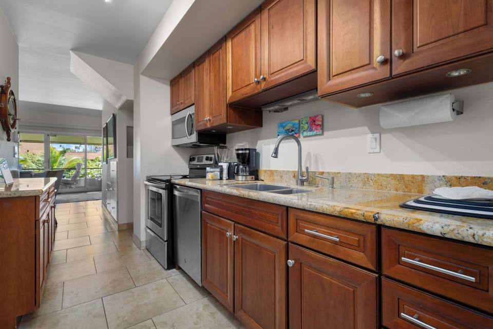 Your fully equipped kitchen features granite countertops, rich wood cabinetry, and stainless steel appliances—everything you need to prepare meals with ease and comfort during your stay.