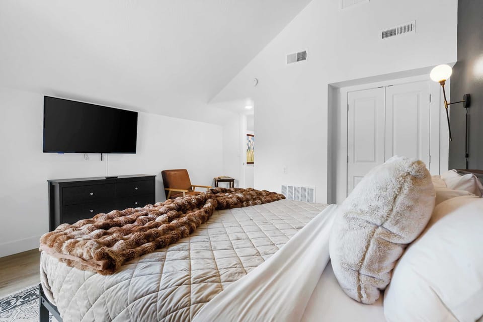 Recharge in the elegant king bedroom, showcasing a smart TV & deck access