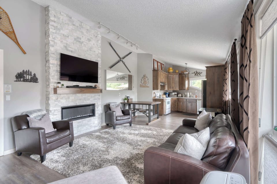 Living room with fireplace and kitchen view.