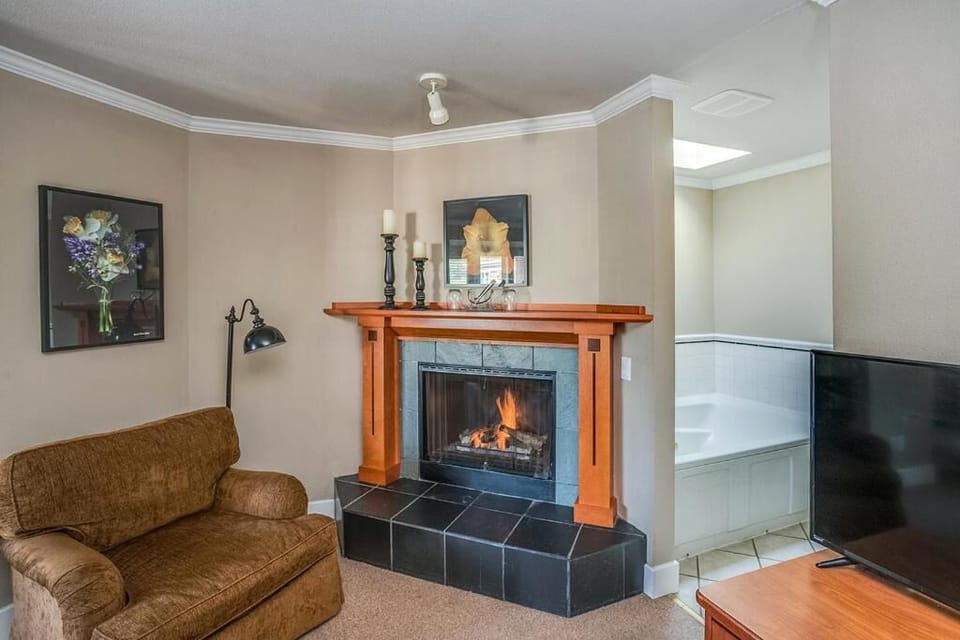Lounge comfortably with an open layout and warm fireplace glow.
