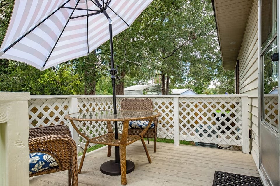 Small back deck with 2 chairs, table, and umbrella.