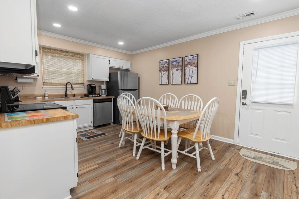 Modern kitchen with stainless steel appliances, coffee makers & utensils.