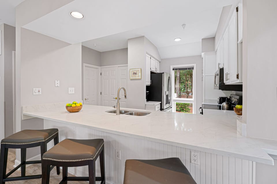 A spacious breakfast bar with seating invites casual meals and conversation, while recessed lighting keeps the space bright and welcoming.