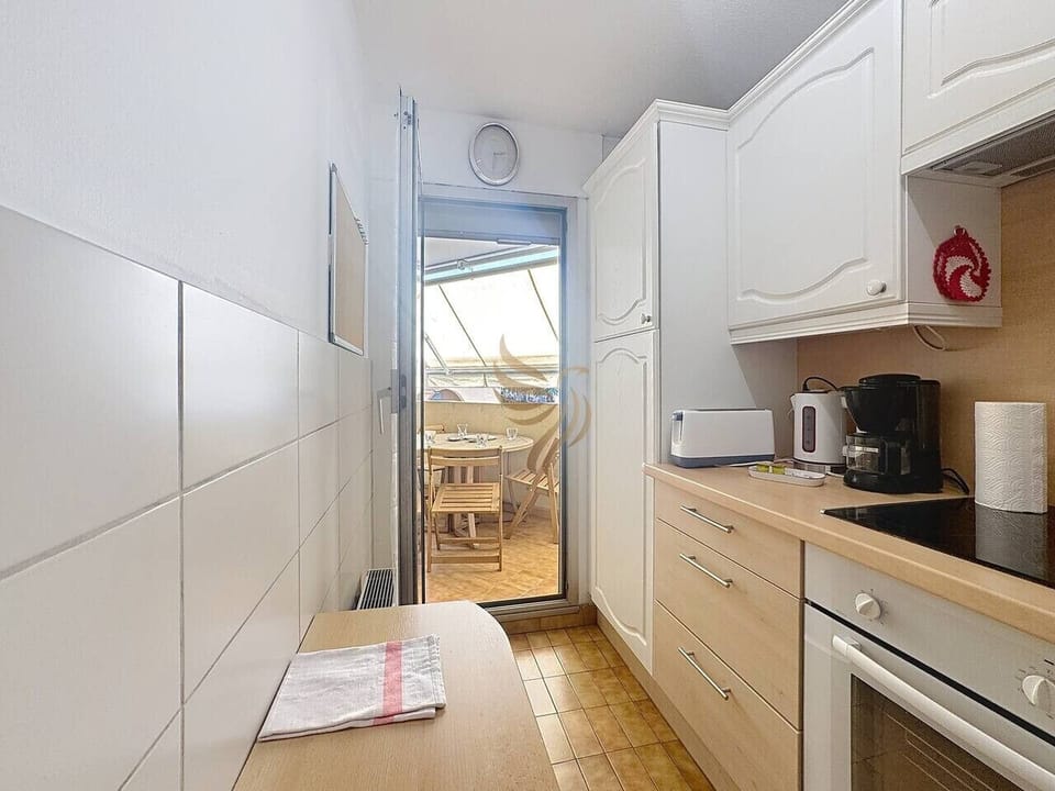 Cuisine lumineuse avec accès direct à la terrasse pour profiter pleinement des repas en extérieur.