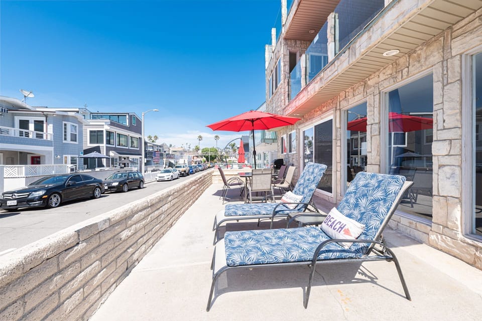 The main living area includes a sofa/loveseat set, side seating, cable TV, and a sliding glass door that opens to expansive front oceanview patio.
                