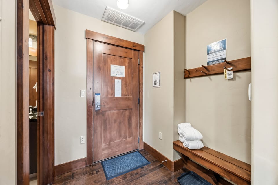 Foyer entry — keypad lock, mudroom bench, hardwood floor.