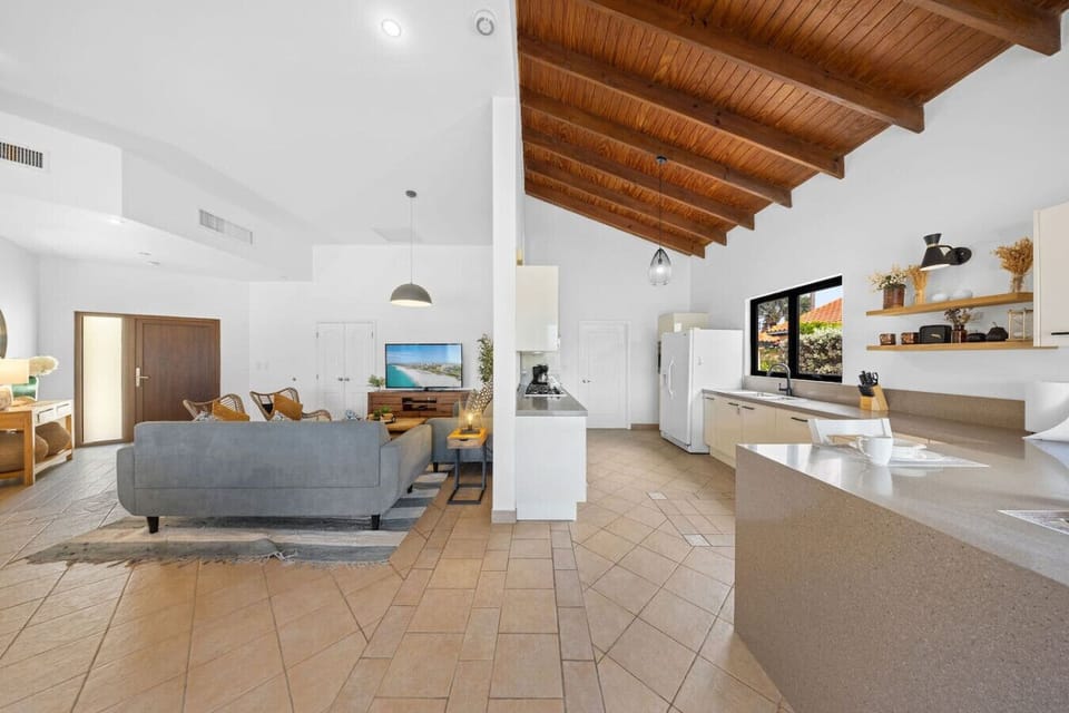 This bright, open layout brings the kitchen and living area together perfectly—cook, chat, and relax all in one beautiful space with high ceilings and plenty of natural light.