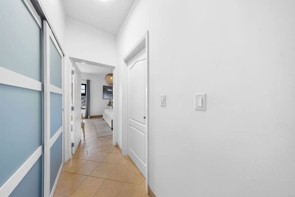 This bright hallway leads you straight to comfort, offering a glimpse into the cozy bedroom ahead. Clean lines, soft lighting, and a peaceful vibe set the tone for a relaxing stay.