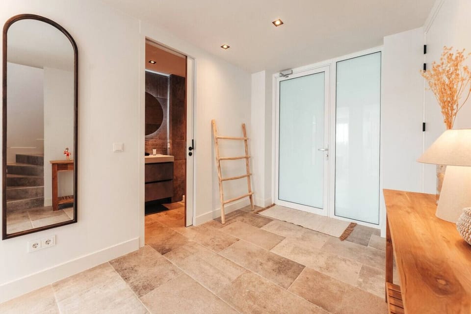 This bright entry space is both welcoming and functional, with warm decor, a full-length mirror, and easy access to the downstairs bathroom—perfect for settling in and feeling right at home.