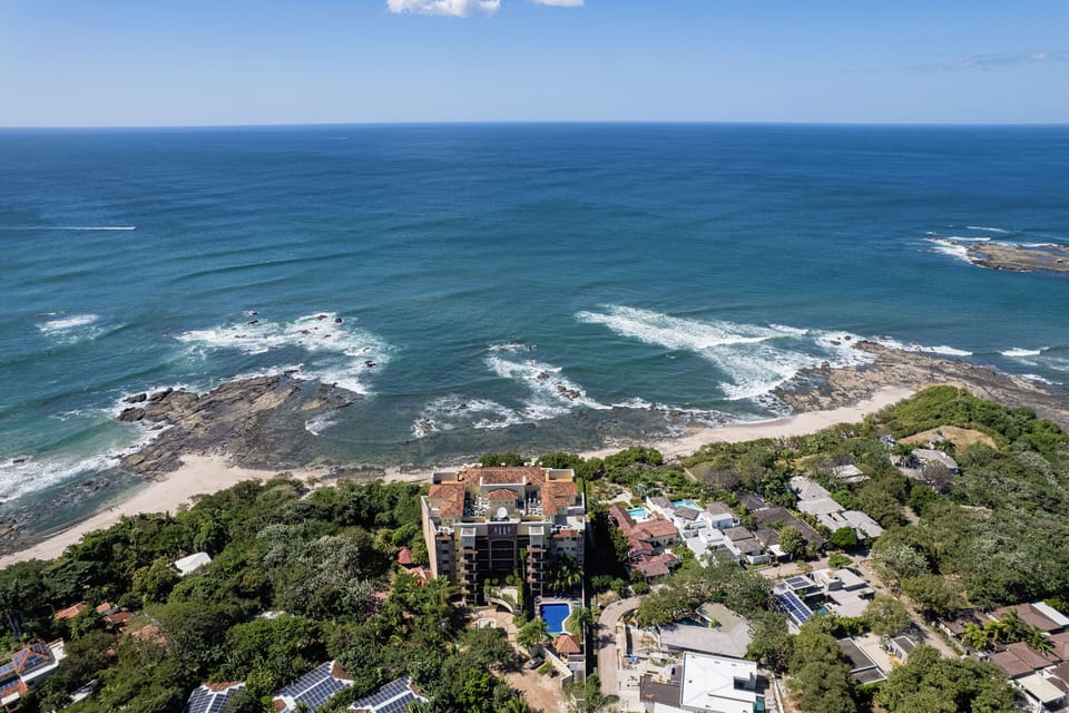 Aerial view of this beachfront Langosta Beach apartment, perfectly located steps from the sand. Enjoy easy beach access, tropical surroundings, and a prime spot for families or groups seeking a luxury Tamarindo vacation rental.