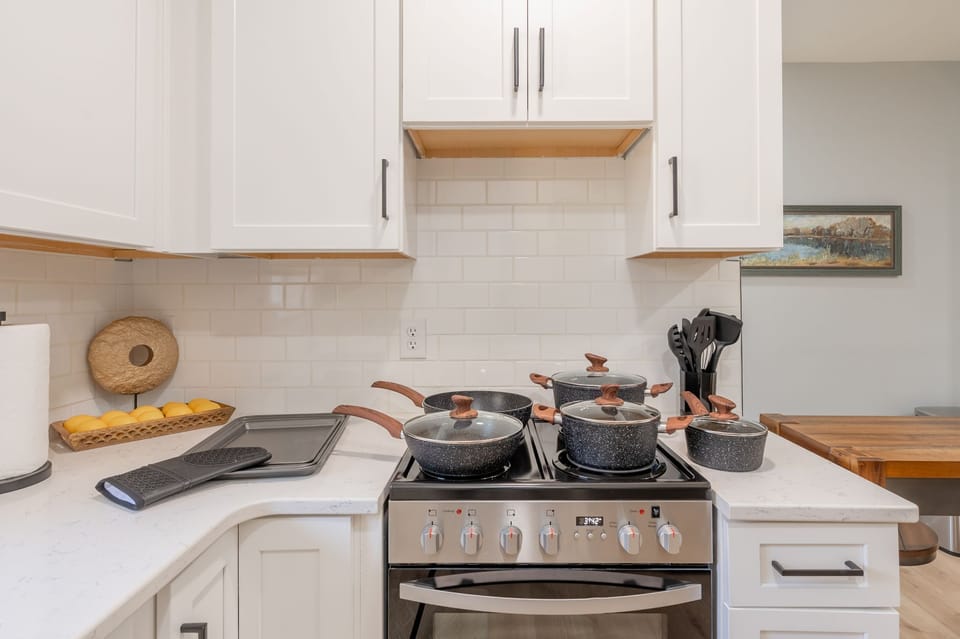 Cook with ease using a fully stocked kitchen featuring a gas range and modern cookware.