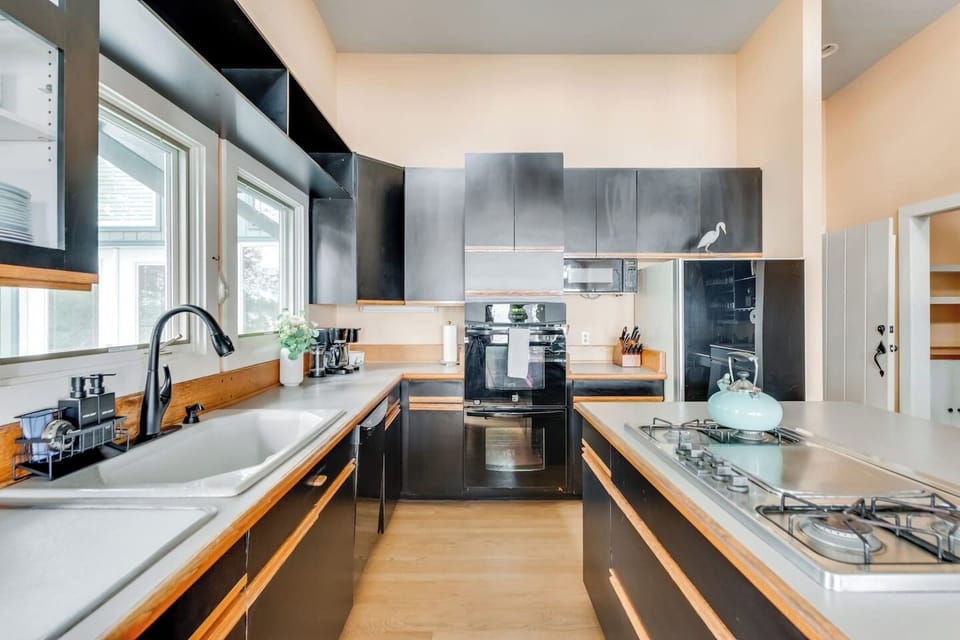 Fully Stocked Kitchen: Cook with style amidst sleek cabinetry and abundant natural light!