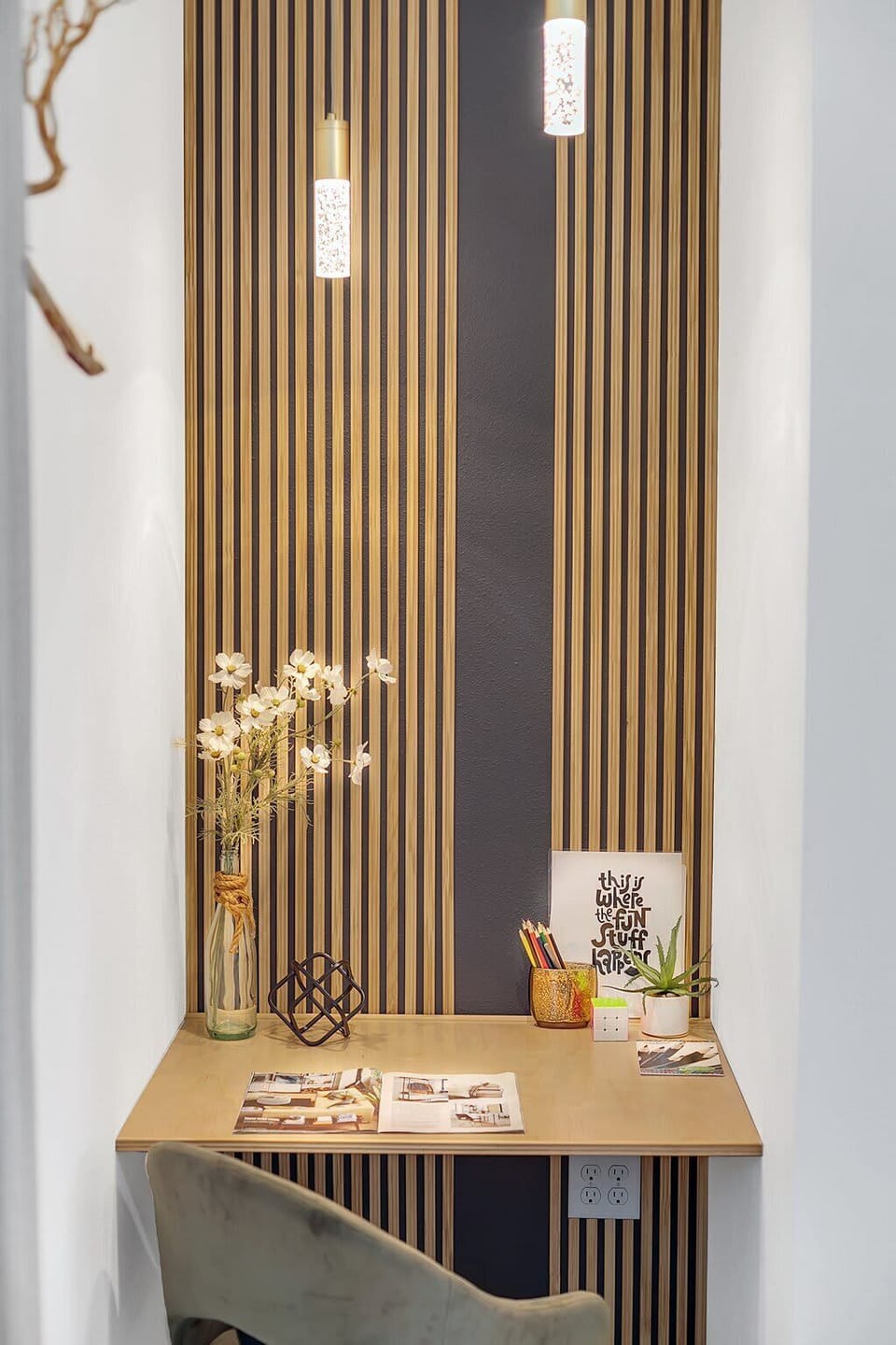 Compact workspace with striped wood paneling and soft pendant lighting.