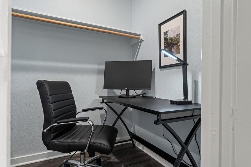 Dedicated workspace with desk, monitor, and comfy office chair