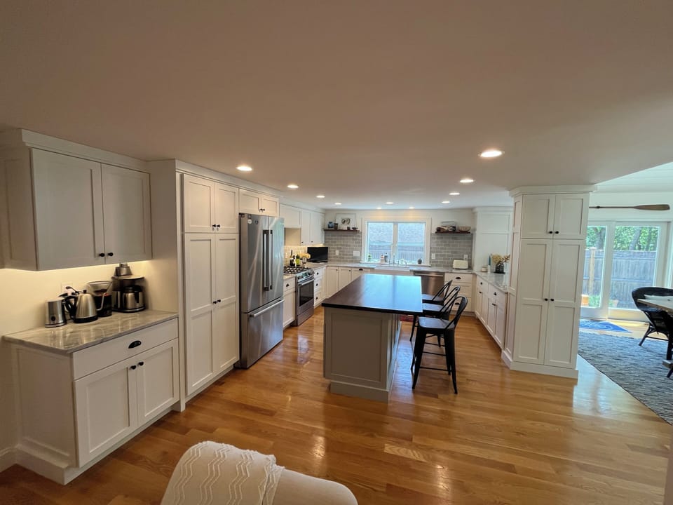 bright kitchen, island with stools, stainless steel appliances, marble counters
