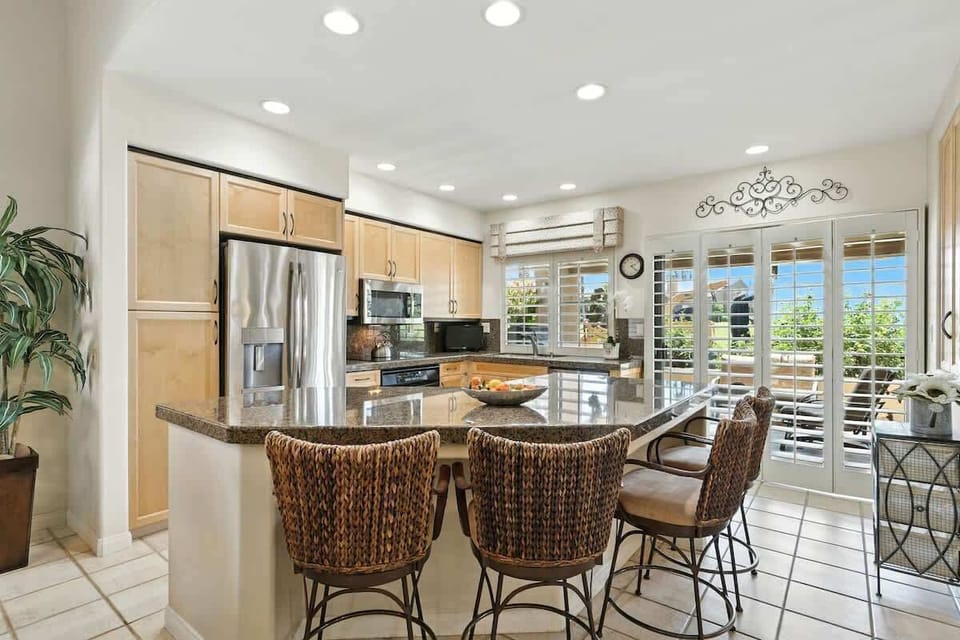 Modern kitchen with stainless steel appliances and a cozy breakfast bar.