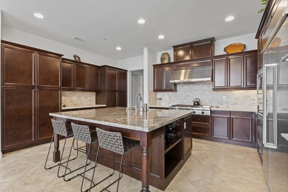 Expansive kitchen layout w/ oversized island & ample counter space for cooking