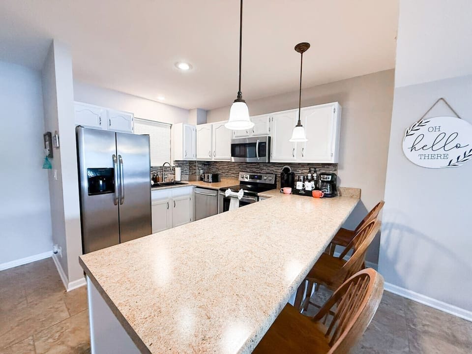 Cook and gather in this well-appointed kitchen, featuring a spacious breakfast bar and modern appliances for your convenience.