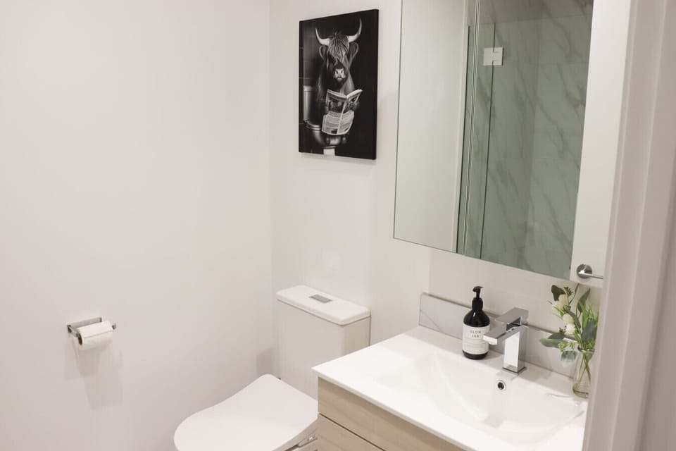 Spacious full bathroom with a walk-in shower, heated towel rack, fresh towels, and all essential toiletries provided.