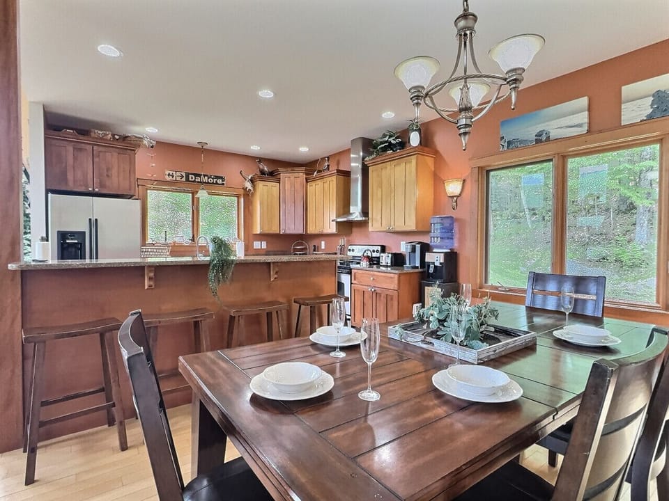 Inviting dining area with a wooden table set for four and a view of the kitchen.